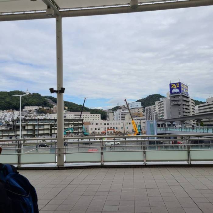 山やビルなどの建物、駐車場などの街並みが写っている写真