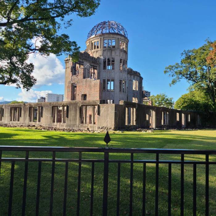 青い空の下、手前には柵、奥には原爆ドームの建物が写っている写真