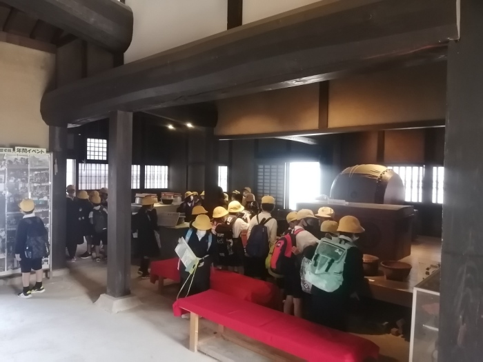 もりぐち歴史館の室内に置かれた展示物を生徒たちが見学している写真