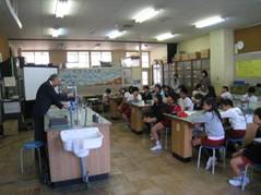 京都大学の大野名誉教授が、下島小学校の児童の前でふりこの実験を行っている様子を写した写真