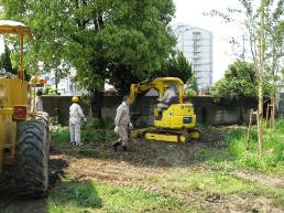 校庭芝生化モデル校になっている下島小学校の校庭に、黄色い重機が点在していて、その間を作業着を着た人々が行き来している写真