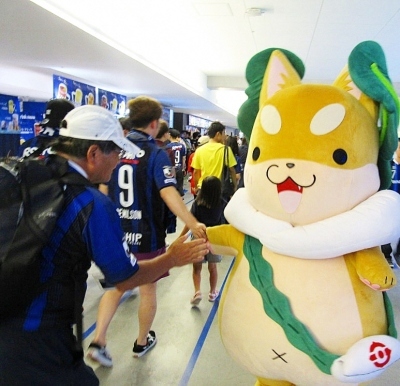 ガンバサポーターとハイタッチをしているもり吉の写真