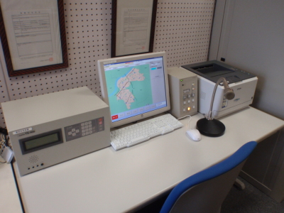 パソコンやマイク、放送用機器が設置されている指令局の机上の写真