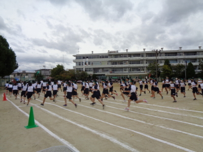 校庭で向かって左方向へ走っている生徒たちの写真