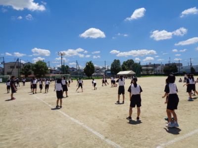 運動場に白いラインが四角に引いてあり、生徒たちがドッチボールをしている写真