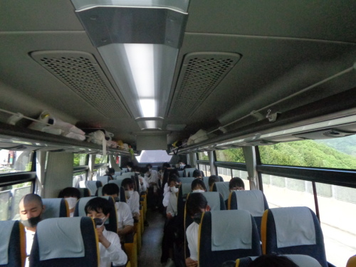 学生たちが座っているバスの車内の写真