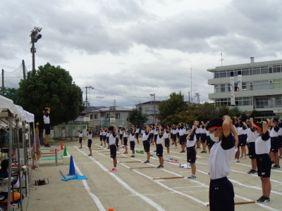 校庭で準備運動をしている生徒たちの写真