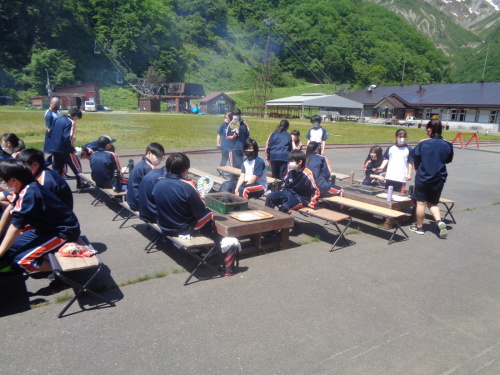 学生たちが着席する焼き台から、煙が出ている写真