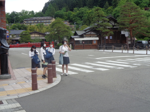 横断歩道の前に立つ4名の女子学生の写真