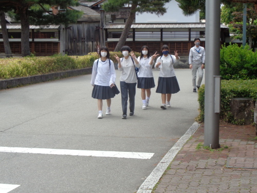 ピースサインをしながら歩いている4名の学生たちの写真