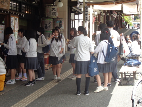 ソフトクリームの置物の横に並んでいる学生たちと、ピースサインをしている女子学生の写真
