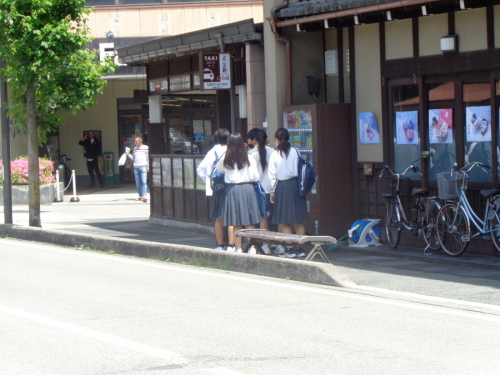 自動販売機の前に立つ学生たちの後ろ姿の写真