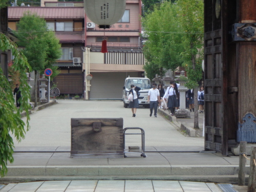 制服姿の学生が、門に向かって歩いている写真