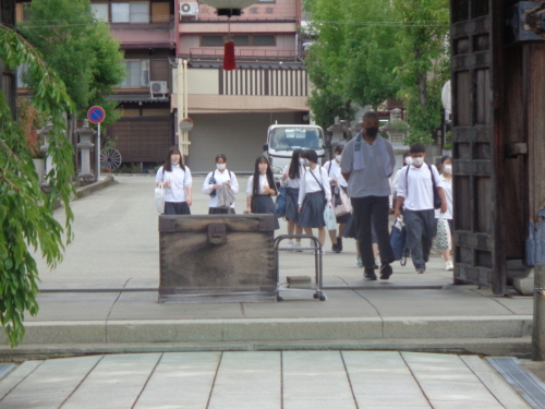 荷物を持った学生たちが、門に向かって歩いている写真