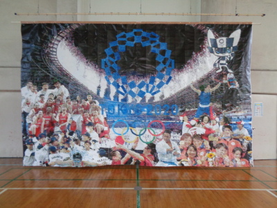 オリンピック選手たちが点で描かれた大きな作品が体育館に展示されている写真