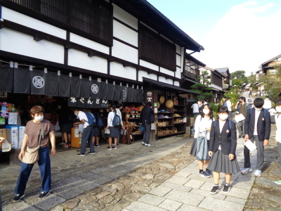 黒い暖簾がされたお土産店をくぐって買い物をする生徒たちと、石畳の道を歩く生徒たちの写真