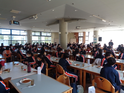 生徒達が席に着き、昼食のカレーを食べようとしている様子の写真