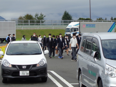 駐車場を歩いている先生や生徒たちの写真