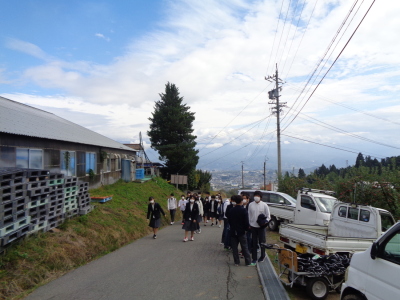 少し傾斜のついた道路を歩く制服姿の生徒たちの写真