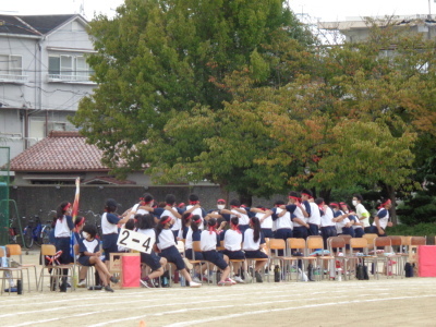 校庭の応援席で立ちあがった生徒が円陣を組んでいる写真