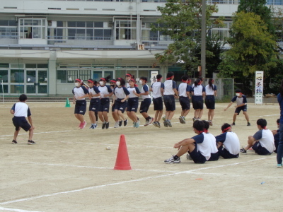 赤組の生徒たちが大縄を飛ぼうと一斉に飛び跳ねている写真