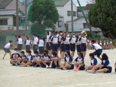 校庭で赤組の生徒がみんなで大縄を飛んでいる写真