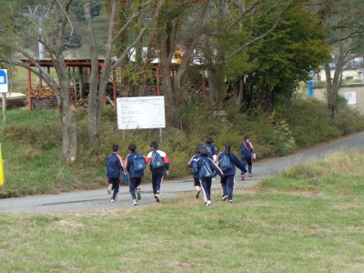 リュックを背負った生徒8名ほどが腕を振りながら歩いている写真