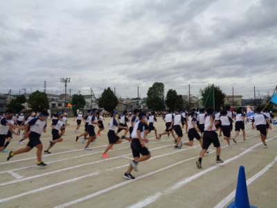 校庭で向かって右方向へ一斉に走り出す生徒たちの写真