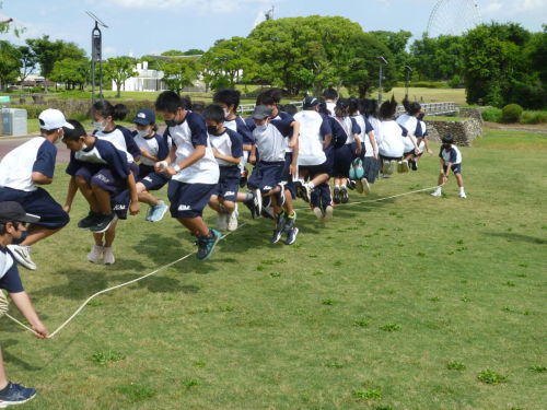 息を合わせて大縄跳びを飛ぶ生徒たちの写真