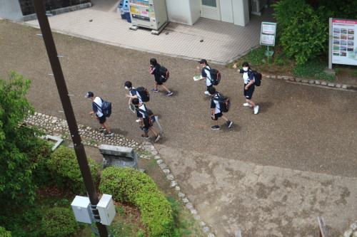 ピースサインをしながら歩いている学生たちの写真