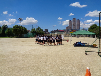 校庭で生徒が輪になって団結している写真