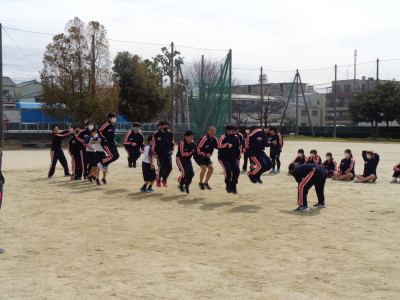 校庭で大縄跳びを行っている生徒たちの写真