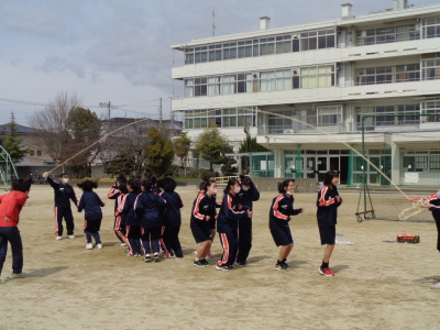 縦に並ぶ女子生徒たちの頭上を長縄が通っている写真