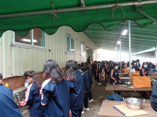 建物側の手洗い場で女子生徒が並んで手を洗っている写真