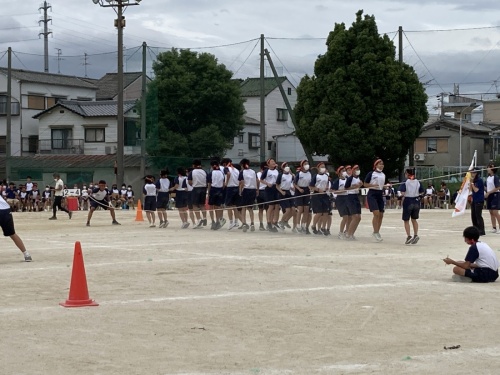 赤組の生徒達が縦に並んで長縄を飛んでいる写真