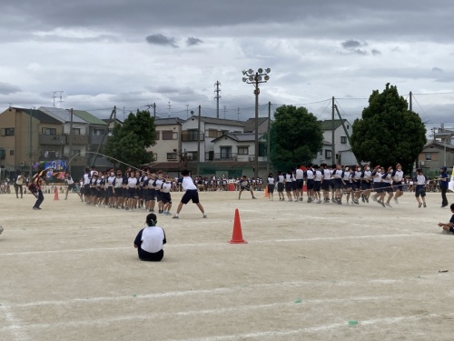 赤組の生徒たちが二組に分かれ長縄を飛んでいる様子を写した写真