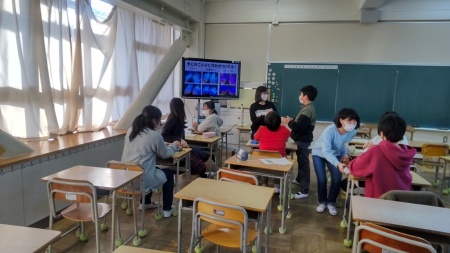 教室のモニターに映像が映されており、生徒達が友達同士で話し合いをしている様子の写真