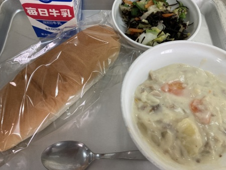トレイに並べられたコッペパン・牛乳・シュクメルリ・白菜とひじきのサラダの給食の写真