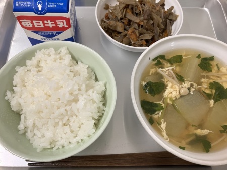 左上に牛乳、時計回りにきんぴらごぼう、とうがんのかき卵汁、ごはんがトレーに並べられた給食の写真