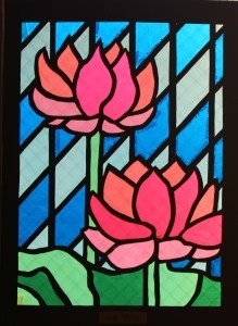 ひし形の幾何学模様の前に蓮の花が描かれているステンドグラスの作品の写真