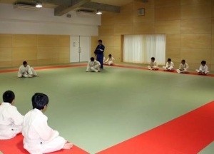 道着を着用した生徒たちが柔道の授業を行っている武道場の写真