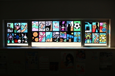 ボールや桜、キャラクターなどが描かれたステンドグラスの作品が並んでいる写真