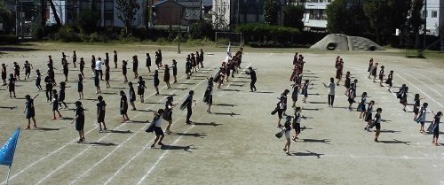 運動場に児童が列になって立ち、ソーランの踊りを練習している様子の写真
