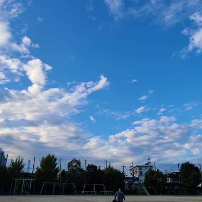 白い雲と青空、グラウンドが写っている写真