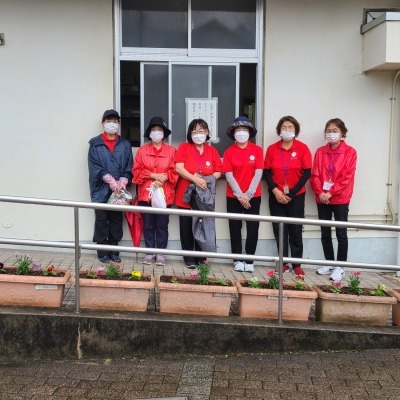 赤いシャツを着た更生保護女性会の方々6名が並んで写っている写真