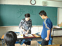 学校の教室で女性が男の子に指導をしている写真