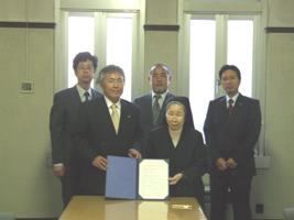 守口市教育委員会と大阪信愛女学院短期大学との調印式に出席した5名の記念撮影写真