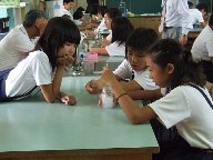 守口小学校の女子児童が、粉を入れた水道水を混ぜている様子を写した写真
