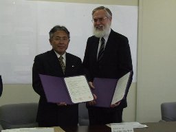 左に藤川教育長、右にTeele学長が協定書を持って立っている様子を写した写真