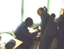 関西外国語大学の学生が錦中学校の生徒に指導している様子を写した写真